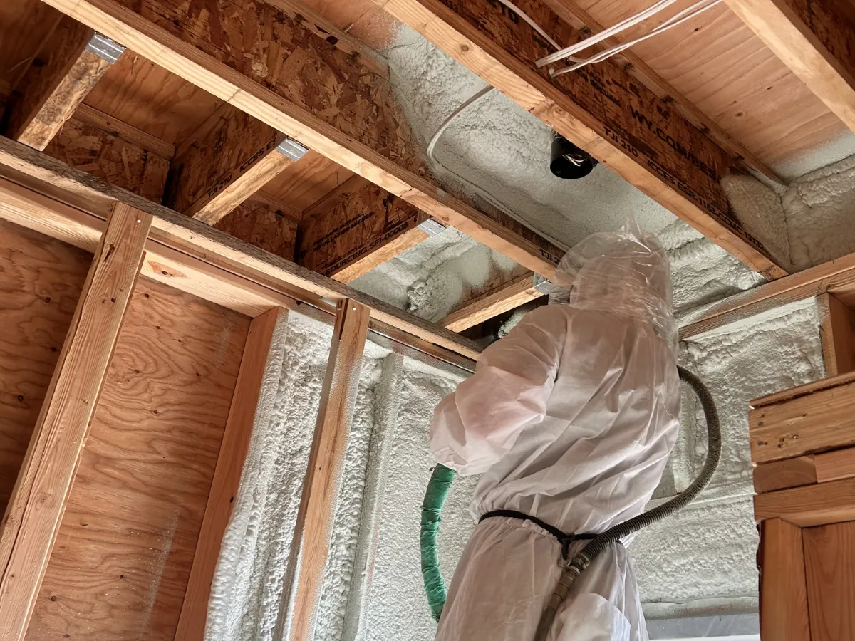 Spray Foam insulation being installed in walls and ceiling of Seasons at Sandpoint Comfort Shed.