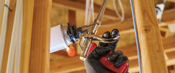 close-up of insulation technician's hand performing air sealing services