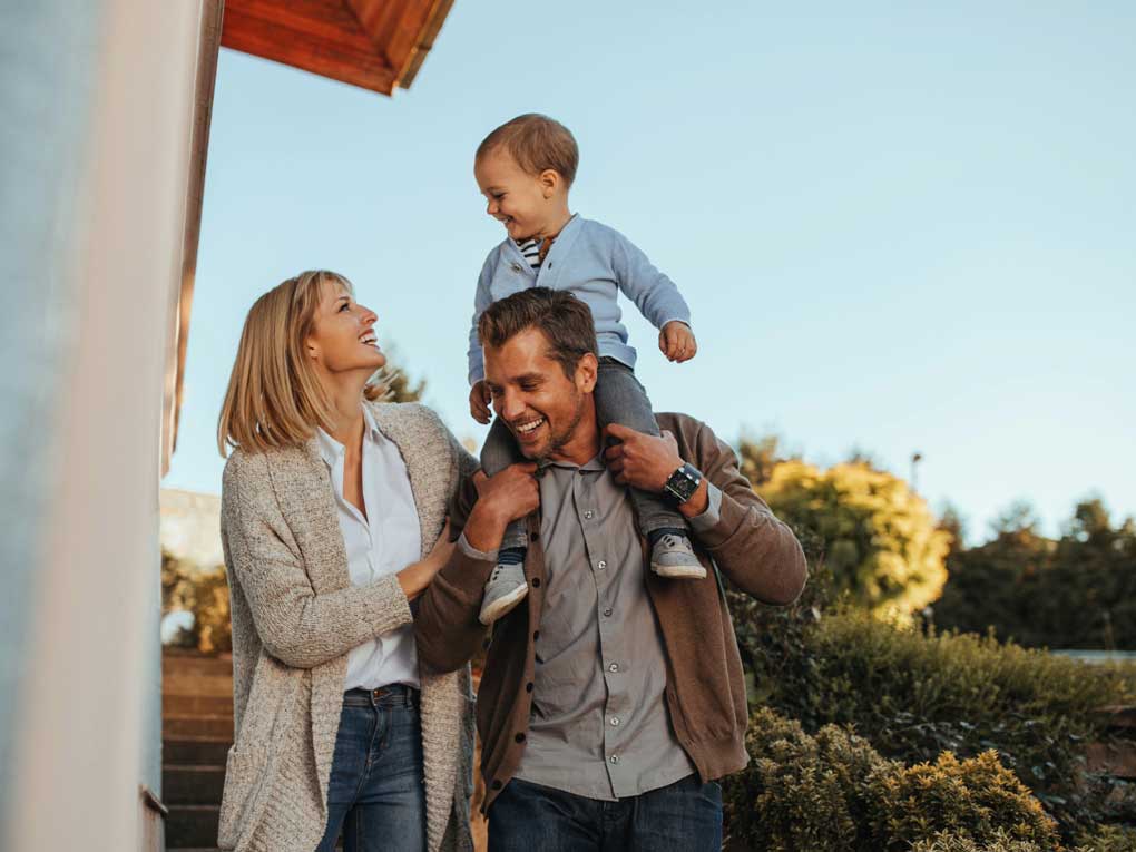 Happy family playing outside of house