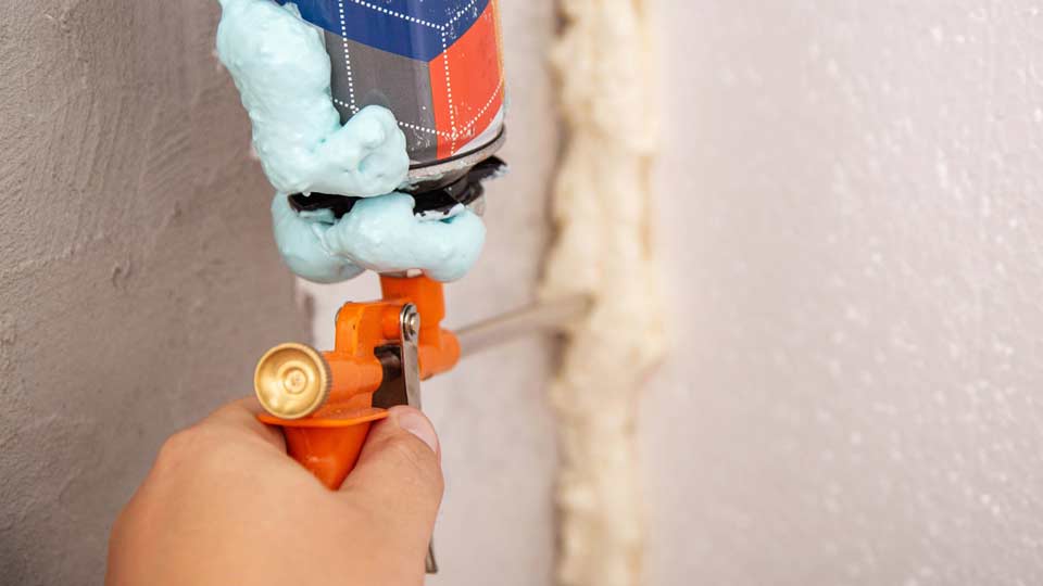 Man's hand holding air sealing gun up close