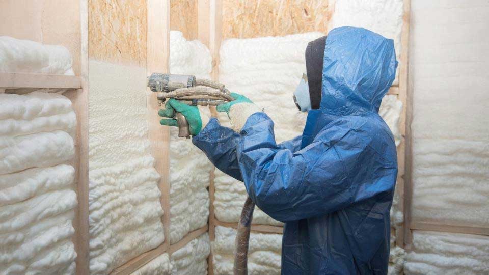 Spray foam insulation installer, insulating home's walls.